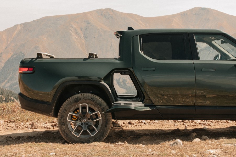 A green Rivian R1T gear tunnel is shown open in right profile view with the desert and mountains in the background