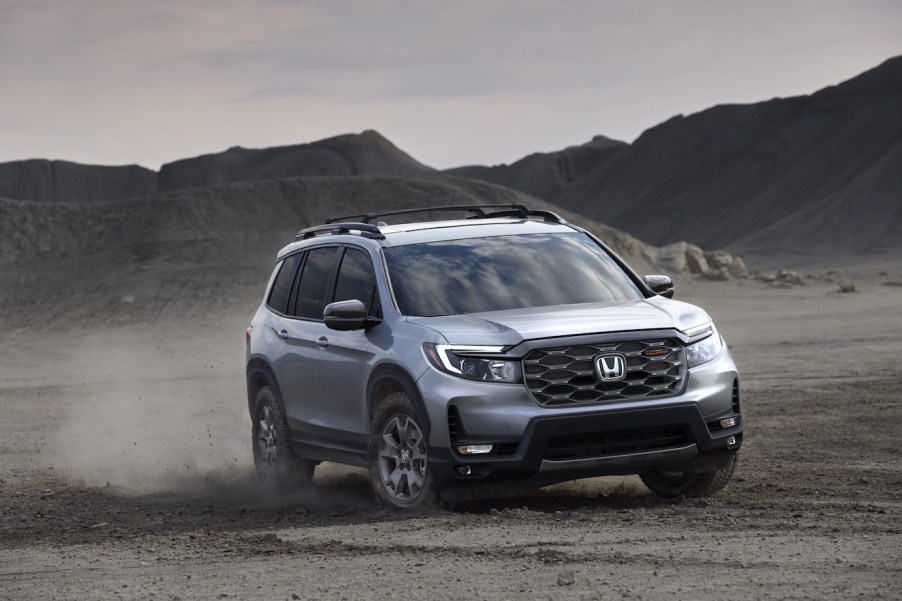 A silver 2024 Honda Passport driving down a dusty road. The 2024 Honda Passport's price makes it tough to justify.