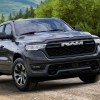 A Ramcharger hybrid pickup truck driving along a dirt road.