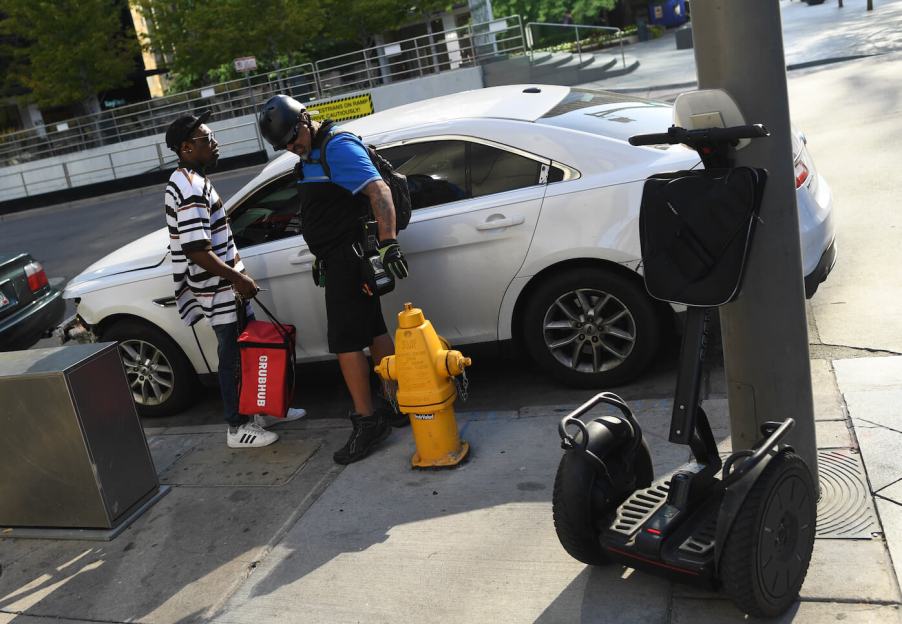 Jeff Gomez, who works doing parking enforcement for the City of Denver, gives a verbal warning to a Grubhub delivery driver that parked infront of a fire hydrant