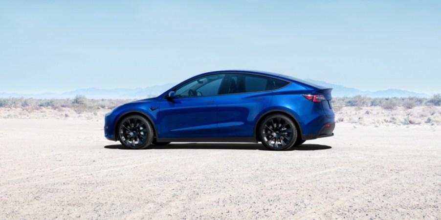 A blue Tesla Model Y small electric SUV is parked.