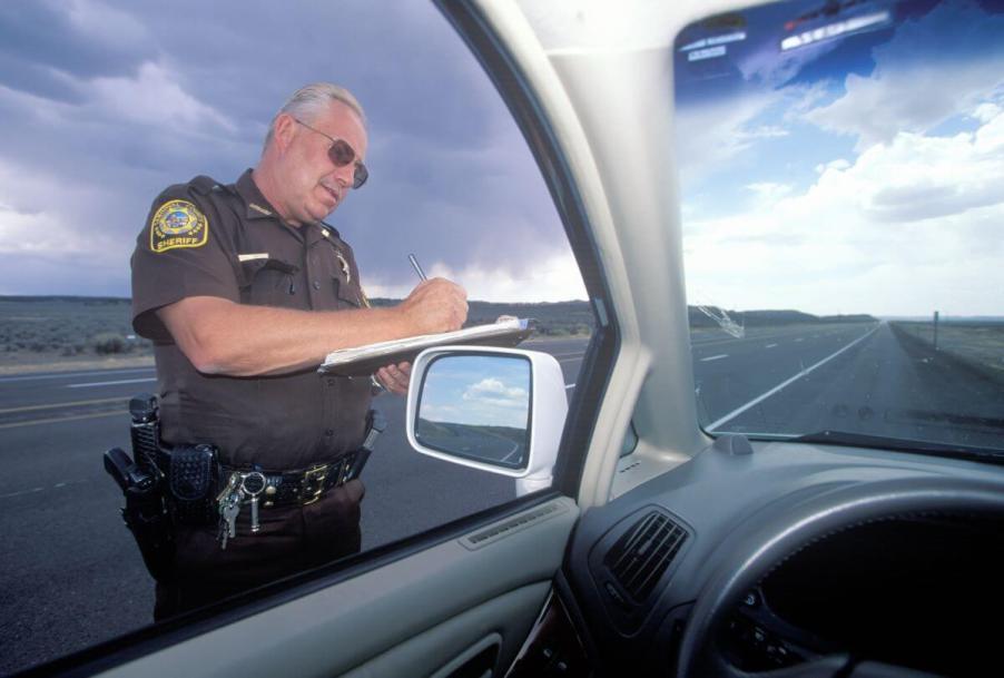 A Sheriff pulling over a driver, where sovereign citizens claim they are driving not traveling