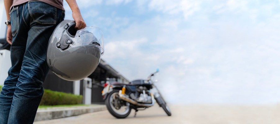 A rider approaches a motorcycle to go for a ride.