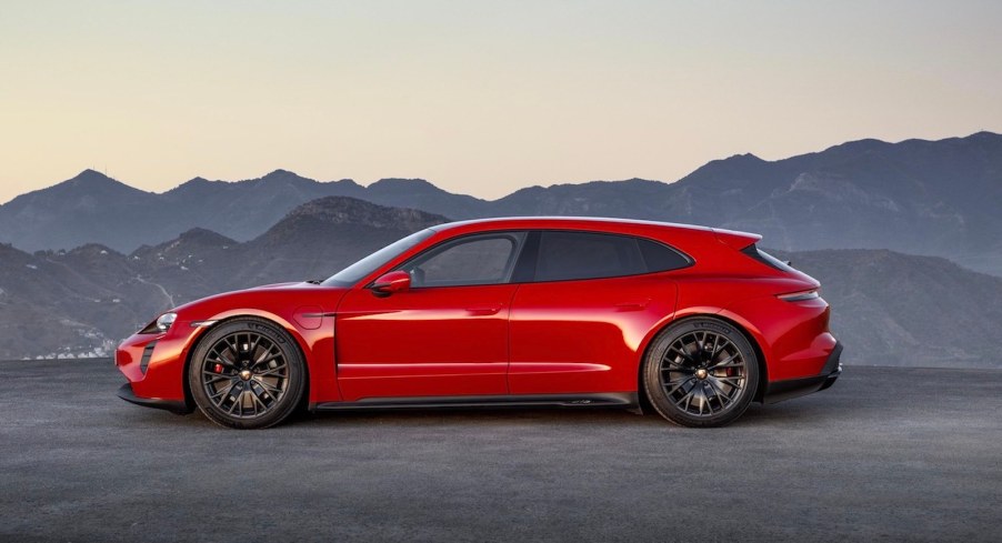 Red Porsche station wagon parked in front of a mountain sunset