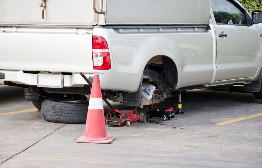 A utility pickup truck on a jack for maintenance