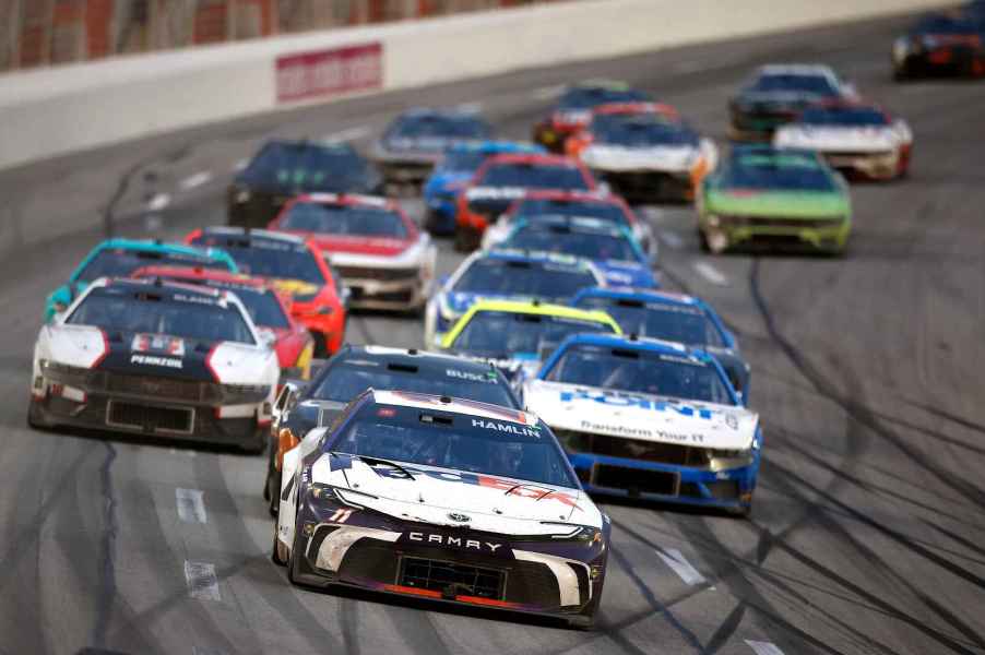 NASCAR cars in a large group on the track during the 2024 Cup Series Ambetter Health 400