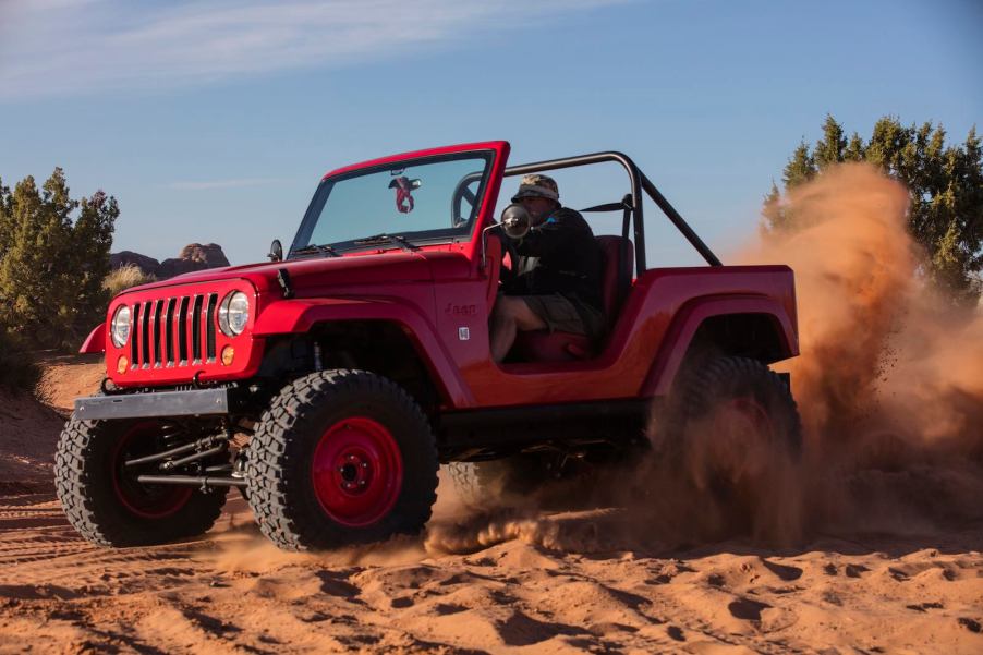 Red Jeep Wrangler shortcut concept 4x4 driving through sand.