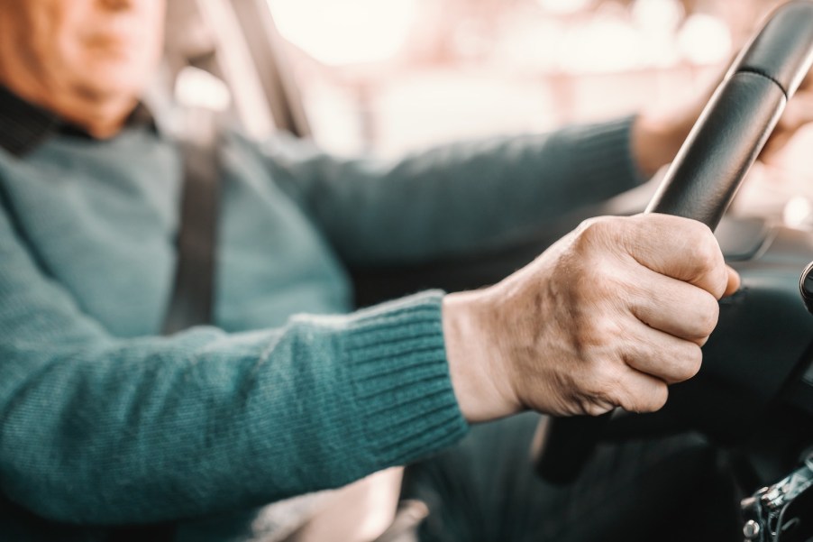 An older man drives his car.