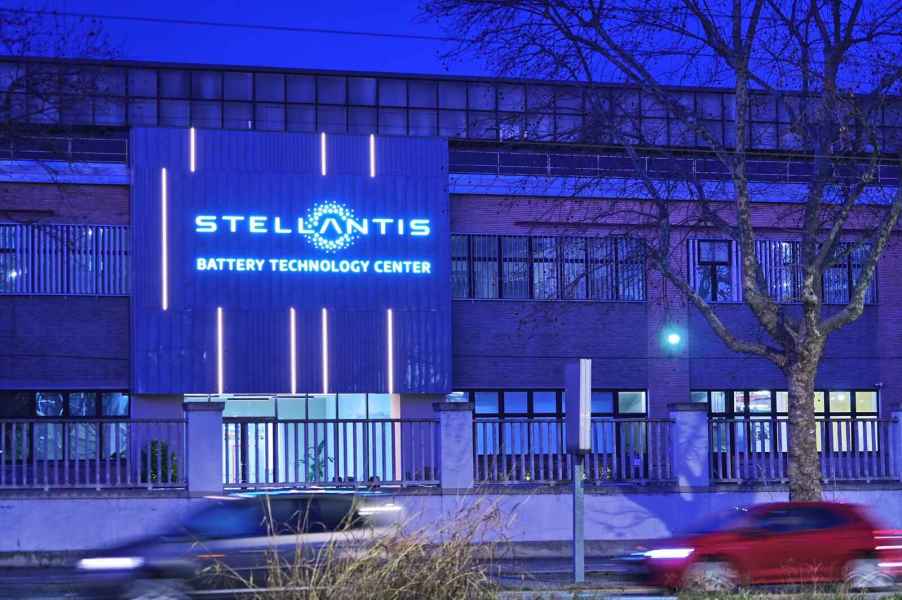 The front of the Stellantis Battery Technology Center is lit up in blue lights dusk