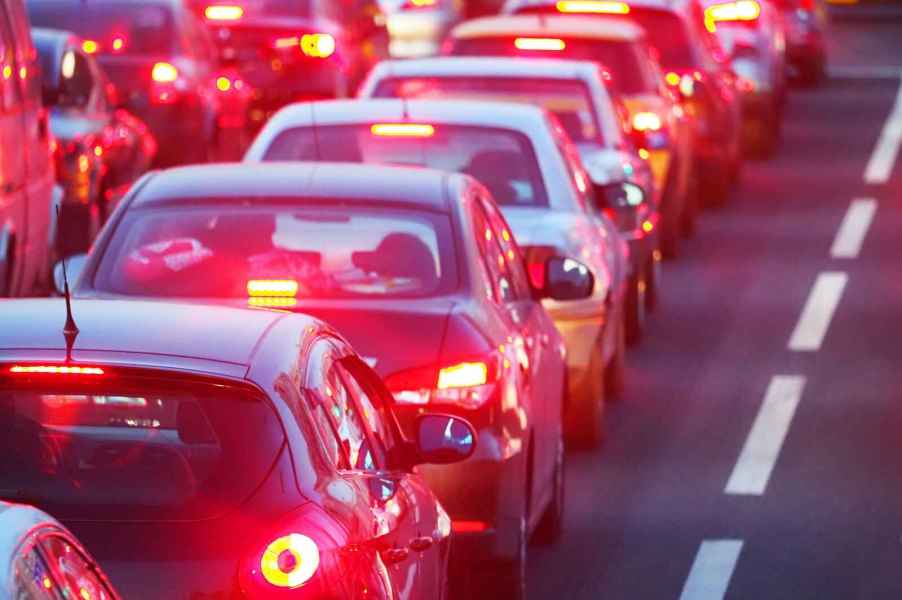 A traffic jam is shown in close view with cars lined up in rear view with brake lights illuminated