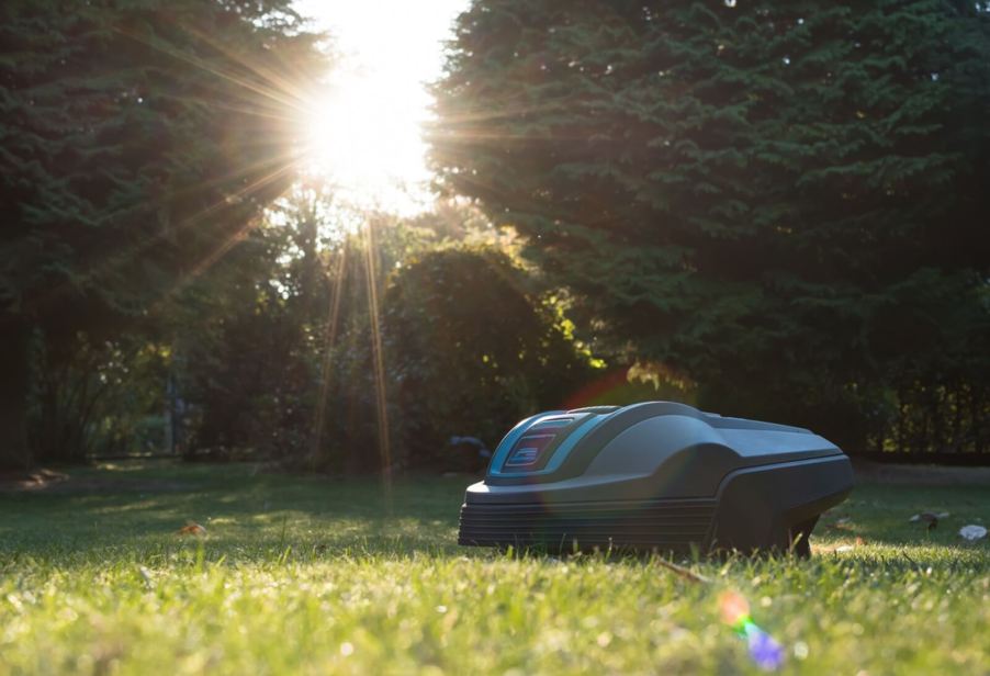 A robot lawn mower cuts a path through a lawn.