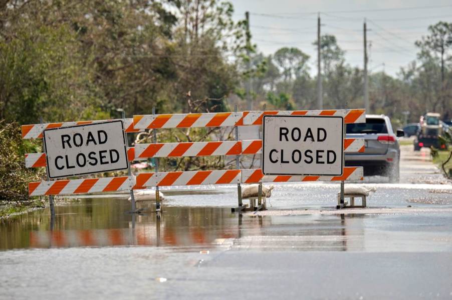 Authorities close a road to keep motorists from driving in flood conditions.