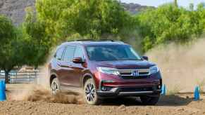 A burgundy 2019 Honda Pilot off-roading in dirt