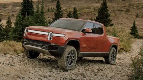 The 2024 Rivian R1T climbing over rocks