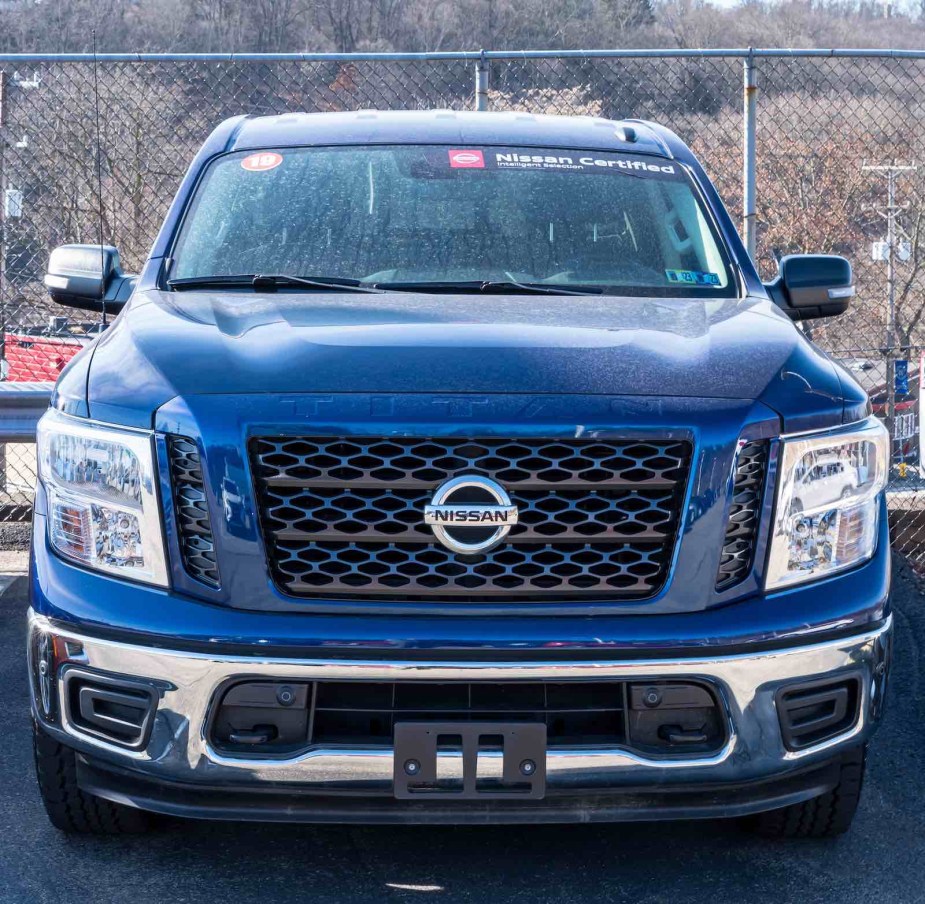 Blue Nissan Titan pickup truck on a used car lot.