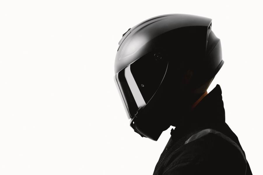 A rider shows off the full-face type of motorcycle helmet from the side profile.