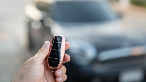 A person using a key fob to unlock their car