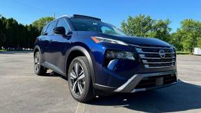 A blue 2024 Nissan Rogue SL AWD shows off its front end styling.