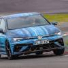 A 2025 Volkswagen Golf R in blue camouflage goes around a track.