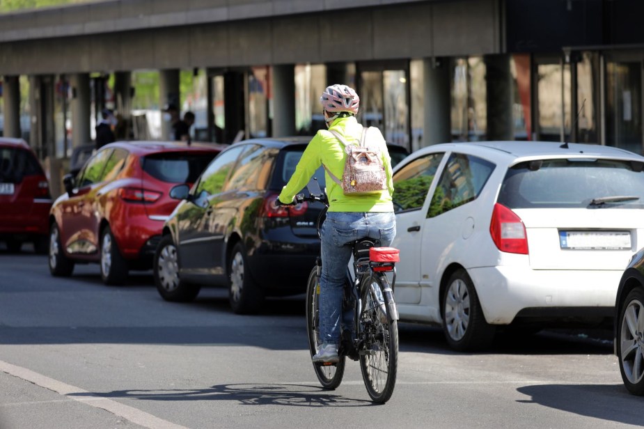 Bicyclist in a neon colored shirt riding through a ciyt.