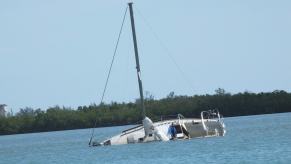 A boat sits in a lagoon after it capsizes.