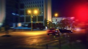 A car running a red light at an intersection at night.