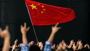 A crowd celebrates Chinese national day by flying a flag