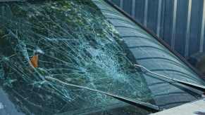 The smashed windshield of a crashed car.