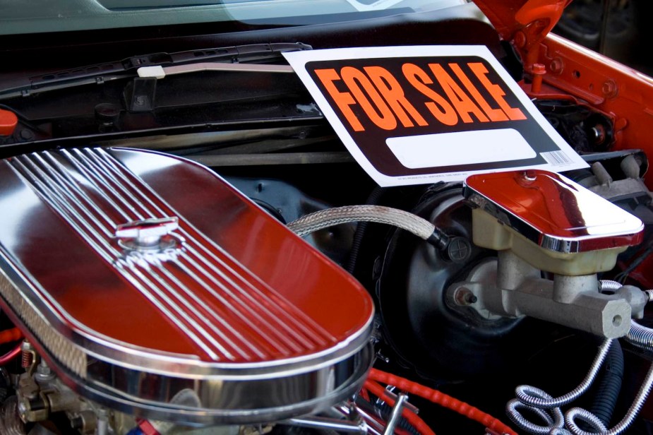 For Sale sign on the engine cover of a V8 muscle car