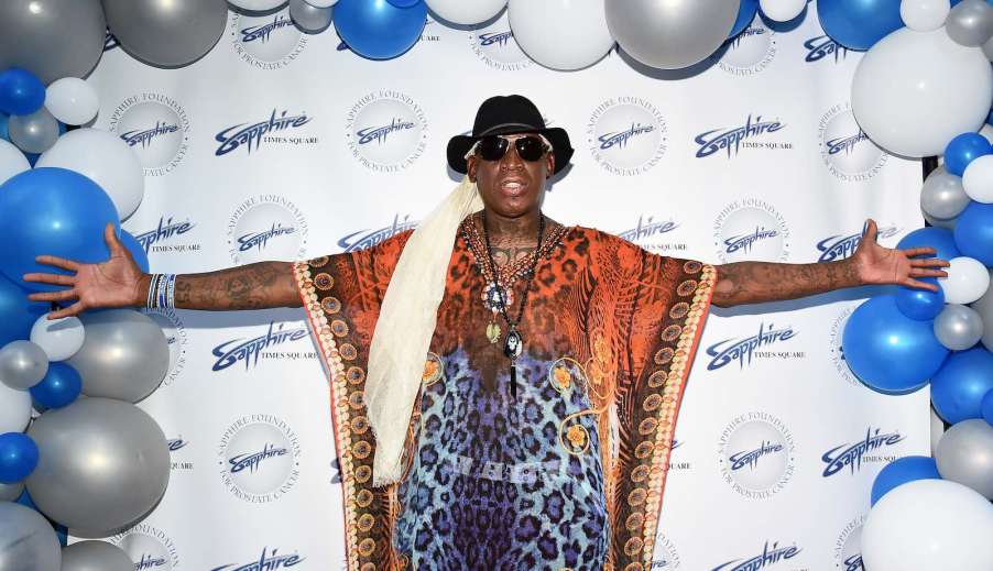 Basketball player Dennis Rodman poses for a photo on the red carpet.