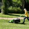 A woman using an electric lawn mower