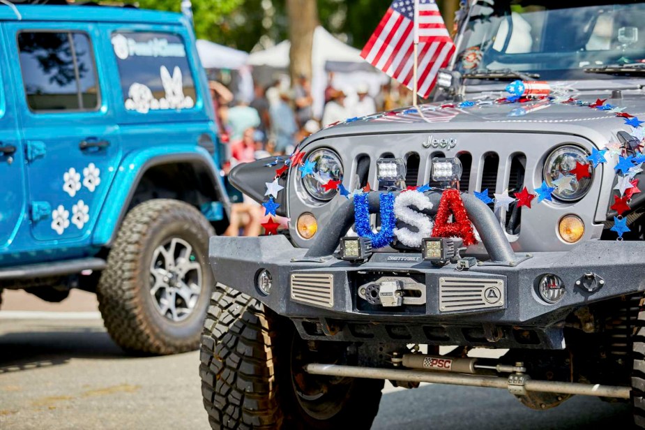 Two Jeep Wranglers decorated with American flags for a 4th of July parade