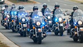 Motorcycle police officers ride in a column.