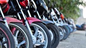 A row of motorcycles parking in a line and saving space.