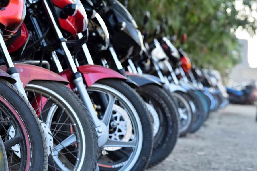 A row of motorcycles parking in a line and saving space.