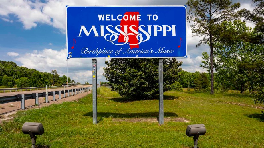 Bright blue "Welcome to Mississippi" sign on the highway.