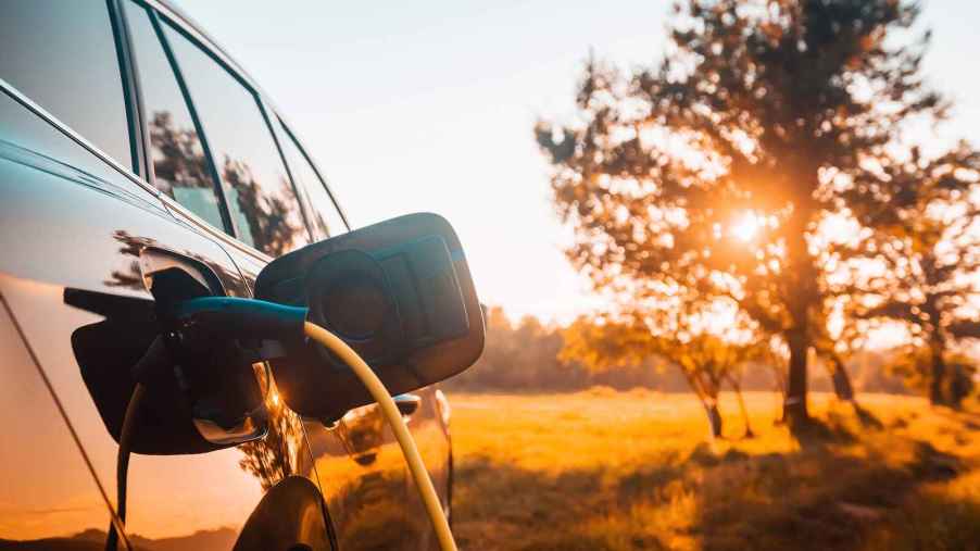 EV charging with sun behind trees EV range topples 17-30% during a heat dome