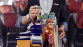 A flight attendant pushing a beverage cart