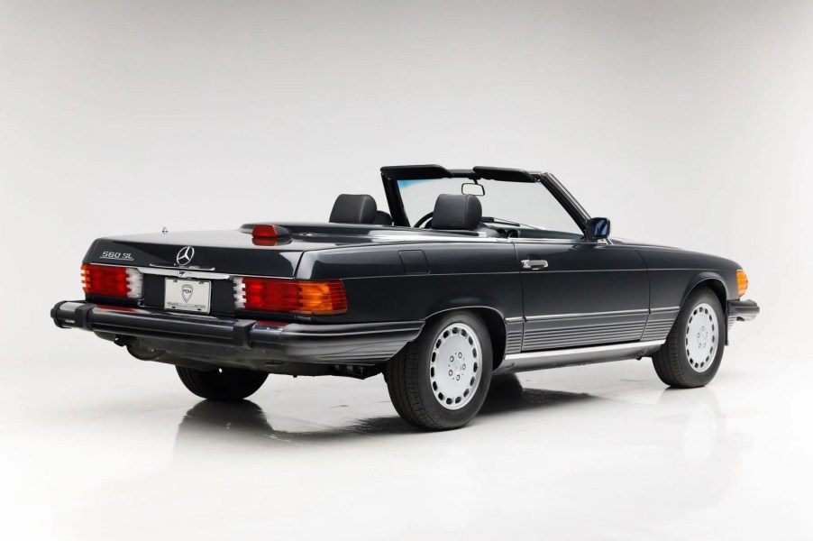 A vintage Mercedes-Benz SL convertible parked in right rear angle view on white floor and background