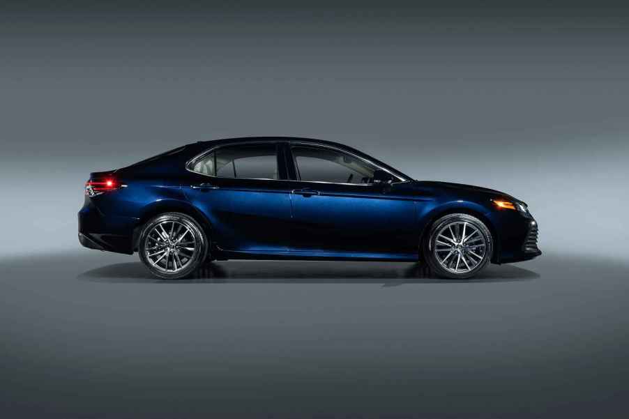 A blue 2021 Toyota Camry parked in right profile view with a grey background the Camry is one of the five highest-selling used cars in the US