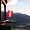 Austrian flag hanging from the porch of a lodge in the Alps mountain range