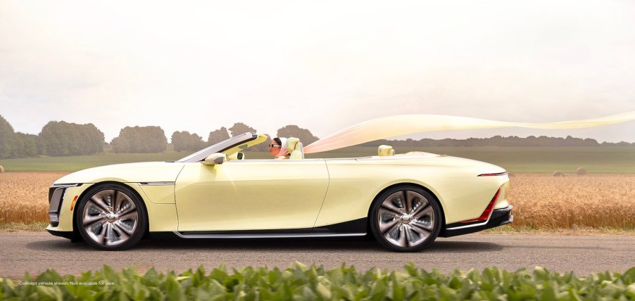 Woman drives a yellow Cadillac convertible concept EV down a country road.