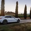 A white 2025 Porsche Panamera E-Hybrid on a country road.