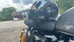 A SHOEI RF-SR motorcycle helmet with a Cardo PACKTALK EDGE Bluetooth unit on a Triumph Thruxton R.