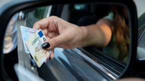 A woman handing her license to a cop