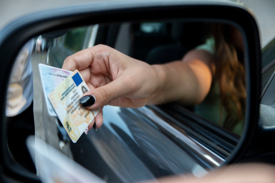 A woman handing her license to a cop