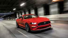 A red 2019 Ford Mustang driving fast in a tunnel