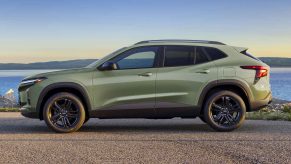 A green 2024 Chevrolet Trax parked in full left profile view in front of water