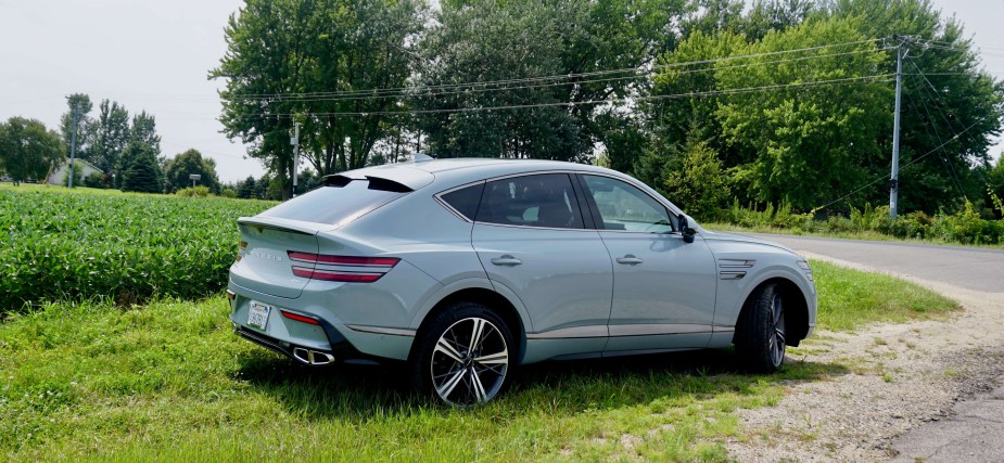 Genesis Coupe Utility Vehicle parked in front of a row of trees.