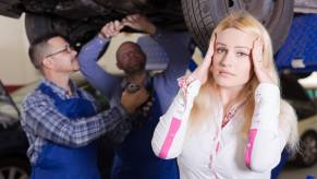 A driver is frustrated by a mechanic and their partner at an auto shop.